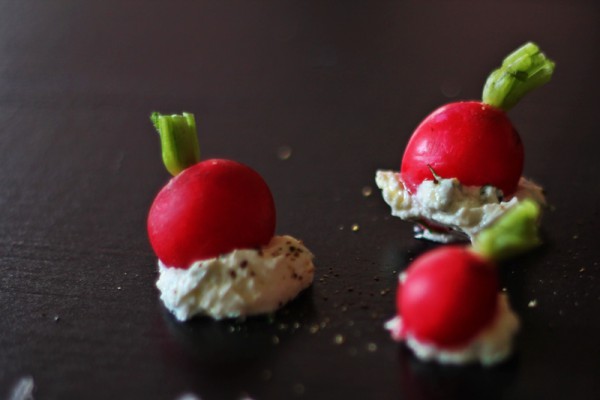 radishes with cream cheese on black background