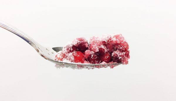 Lingonberries on spoon with sugar